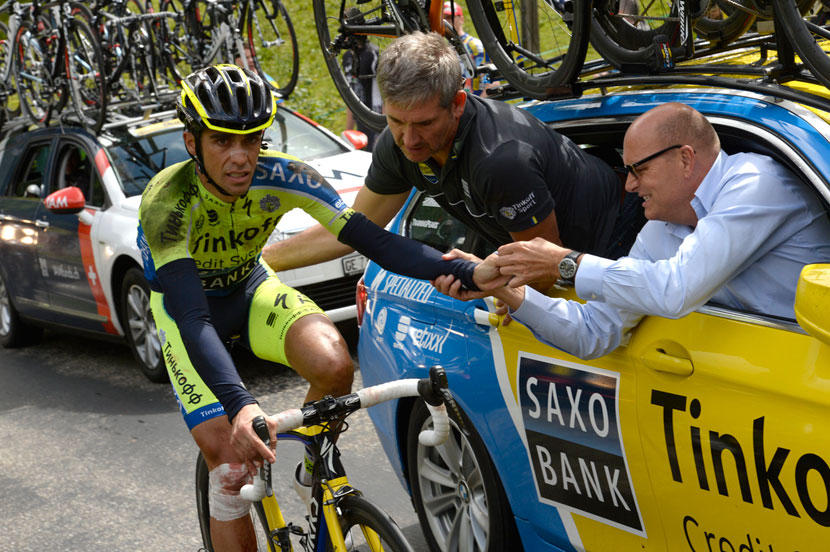 Contador is tended to by Faustino Munoz and Bjarne Riis as he rides along with a fractured tibia after his crash in stage 10 of the 2014 Tour. Photo: Graham Watson